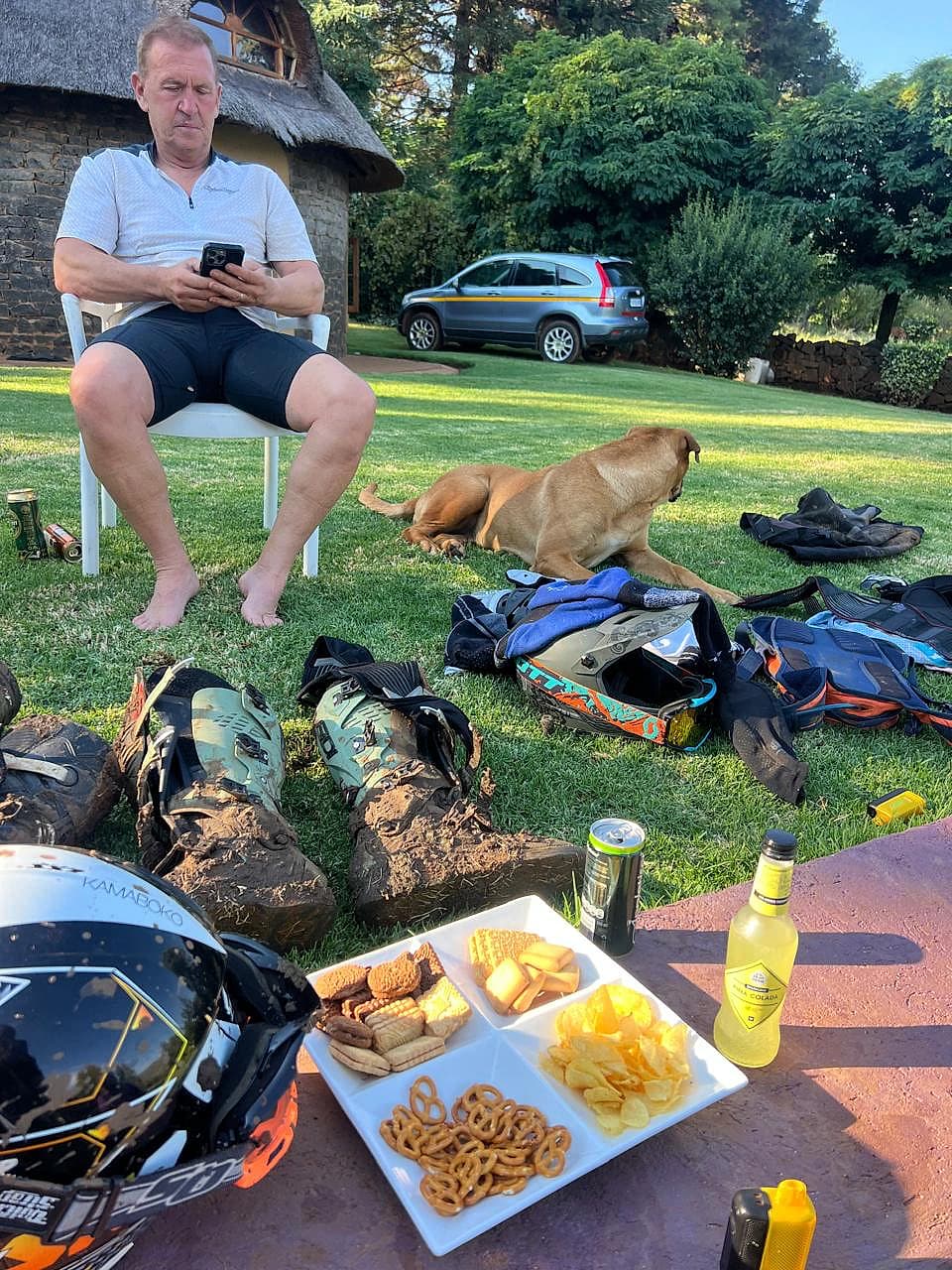 Rider resting beside enduro gear laid out on the lawn